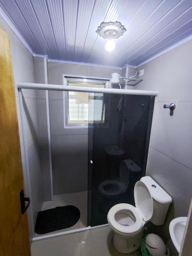 a small bathroom with a toilet and a sink at Apartamento no centro, com garagem e wi-fi in Peruíbe