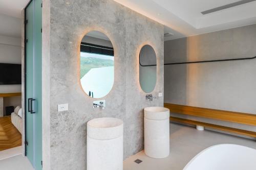 a bathroom with a round window and two stools at CITADEL Heritage Hotel Berat in Berat