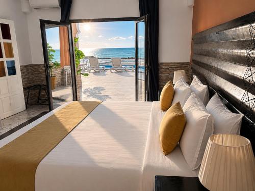 a bedroom with a bed with a view of the ocean at Hôtel Calipau Riad Maison d'Hôtes in Dakhla