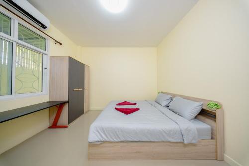 a bedroom with a bed with a red towel on it at Nan's 2 Bedroom House in Krabi