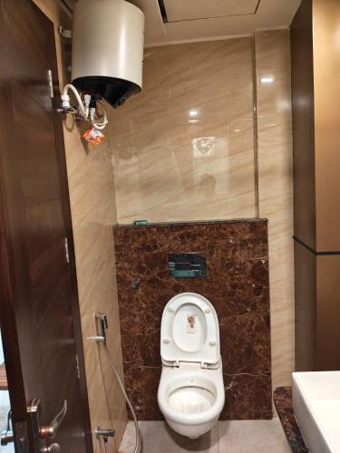 a small bathroom with a toilet in a stall at Crown Palace Hotel & Restaurant in Hāpur
