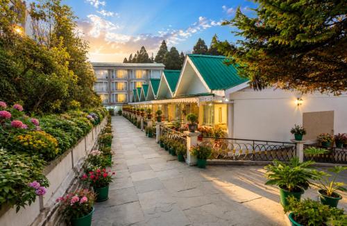 a garden in front of a building with flowers at Sterling Darjeeling in Darjeeling