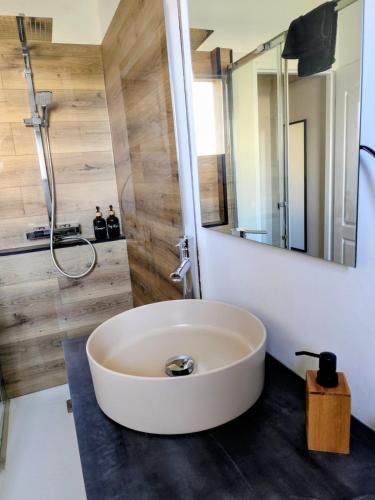 a large white tub in a bathroom with a mirror at L'Orée du Bois in Pulnoy