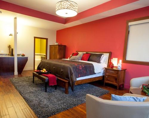 ケロウナにあるHillcrest Farm Market B&Bの赤い壁のベッドルーム1室(ベッド1台付)