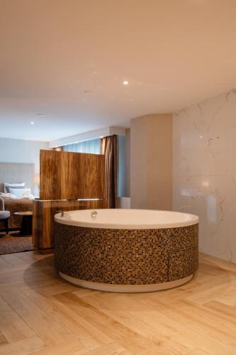 a bathroom with a large tub in the middle of a room at Van der Valk Hotel Hollands Kroon in Wieringerwerf
