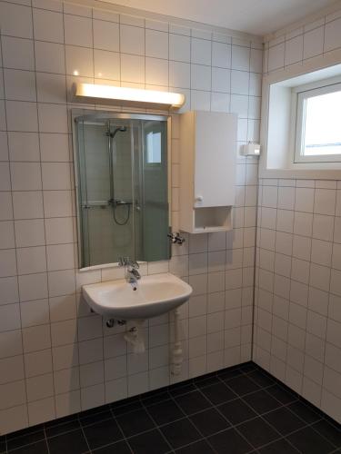 a bathroom with a sink and a mirror at Evjen H0101 in Tromsø