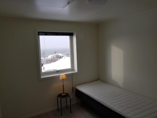 a small room with a bed and a window at Evjen H0101 in Tromsø