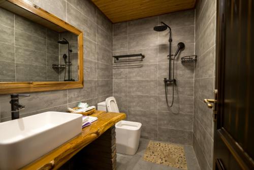 a bathroom with a sink and a shower at 唐韵驿馆 in Dunhuang