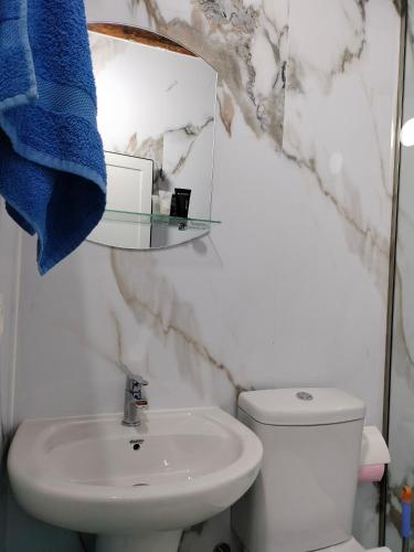 a bathroom with a sink and a toilet and a mirror at Stomici Guesthouse in Ndërlysaj