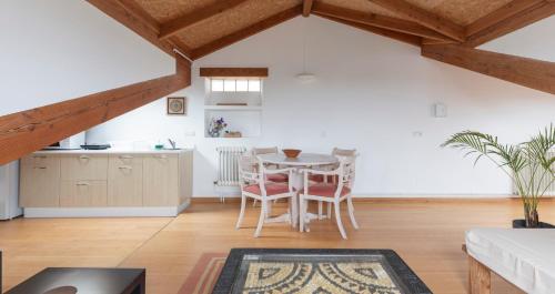a kitchen and living room with a table and chairs at NAMOR - Buhardilla Zen in Ribadeo