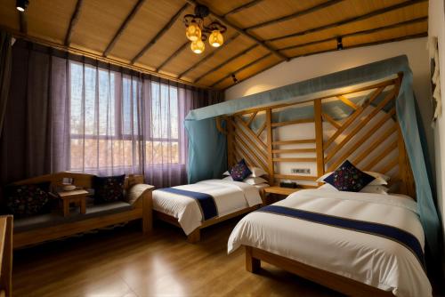 a bedroom with two beds and a couch at 唐韵驿馆 in Dunhuang