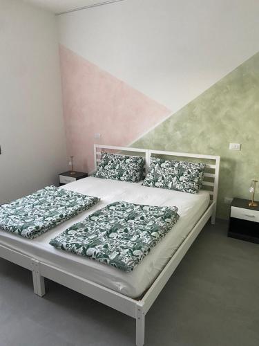 a bedroom with a white bed with pillows at B&B Il Viale in Ponte dellʼOlio