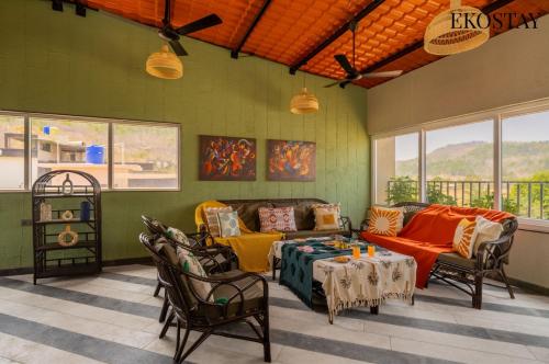 a living room with a couch and a table at EKOSTAY - Casa Elara in Igatpuri