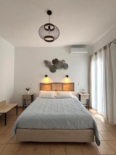 a bedroom with a large bed and a large window at Celeste Apartments in Ornos