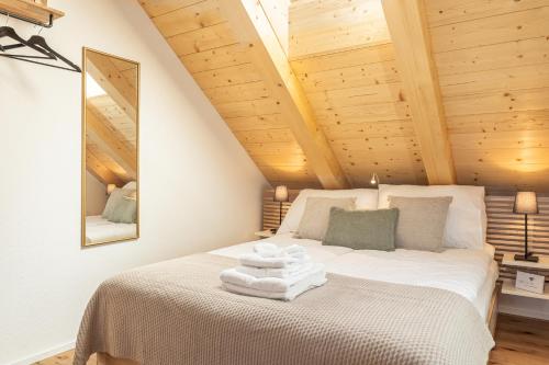 a bedroom with a white bed with wooden ceilings at Appartements Lago in Tüscherz-Alfermée