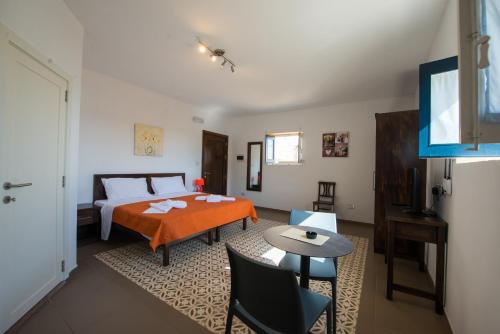 Casa Lapira في فاليتا: غرفة نوم بسرير وطاولة وكراسي