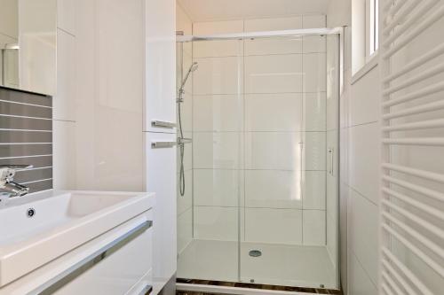 a white bathroom with a shower and a sink at De Ankergooi! in Hardenberg