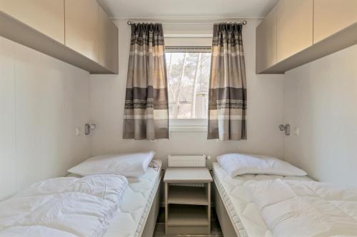 two beds in a room with a window at De Ankergooi! in Hardenberg