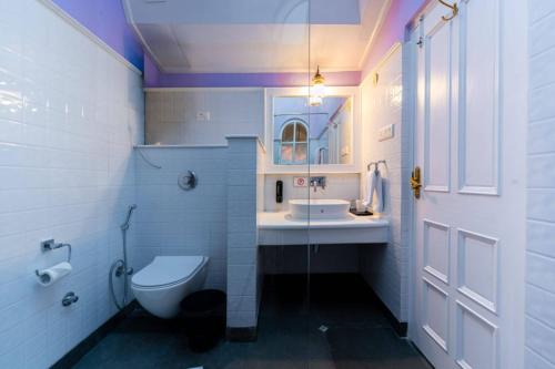 a bathroom with a toilet and a sink and a mirror at Johnson Lodge Manali in Manāli