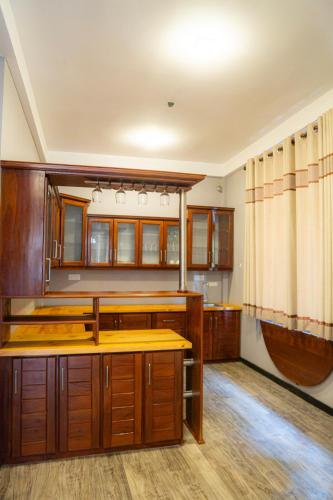 an empty kitchen with wooden cabinets and counters at Diana Residence in Matara