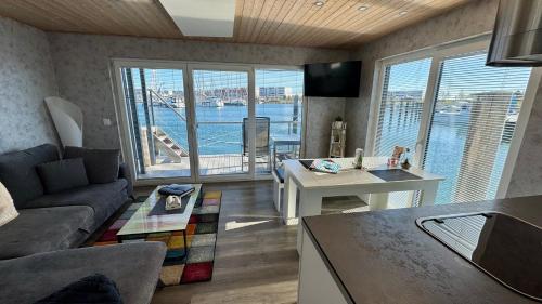 a living room with a view of the water at Hausboot Fehmarn in Fehmarn
