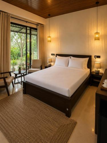a bedroom with a large bed and a living room at Myla Lodge in Anuradhapura