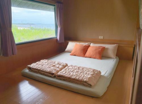 a bed in a room with a large window at 澎湖民宿-旺旺部落 in Magong