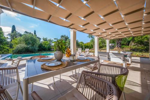 an outdoor patio with a table and chairs at Villa Oliva with Private Pool by Konnect in Kato Korakiana