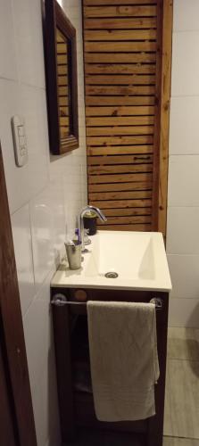 a bathroom with a sink and a mirror and a towel at Días y flores in Ranchos