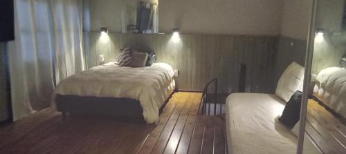 a bedroom with two beds and a mirror at Días y flores in Ranchos