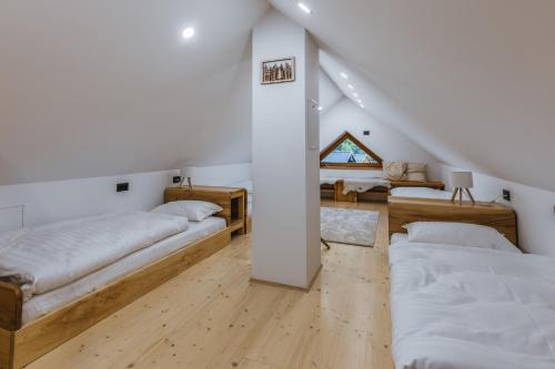 a room with three beds and a table at Alpine HOUSE 77 in Kranjska Gora