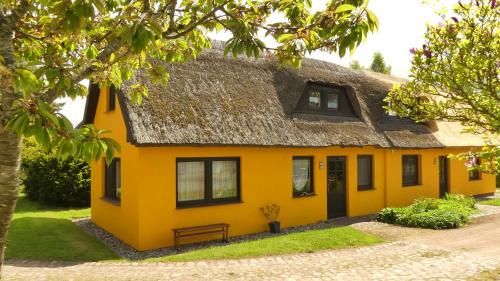 a yellow house with a thatched roof at Ferienwohnung Strandweg 1 in Wieck