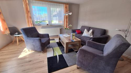a living room with two chairs and a table at Ferienwohnung Strandweg 1 in Wieck