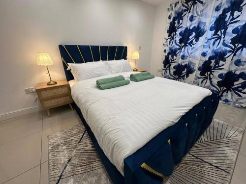 a large bed with two green pillows on it at Stylish 2 Bed Flat Parking Sutton Coldfield in Birmingham
