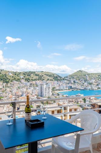 a table and chairs on a balcony with a view of a city at Mariana Apartments in Sarandë