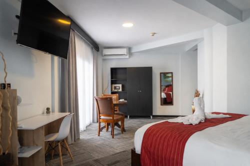 a hotel room with a bed and a table and a desk at Hotel Luckys in San Isidro de El General