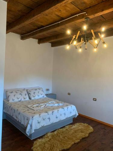 a bedroom with a large bed with a chandelier at Stomici Guesthouse in Ndërlysaj