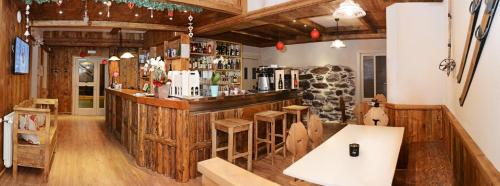 a bar in a restaurant with wooden walls and wooden floors at Hotel Riva Sport & Wellness in Vione