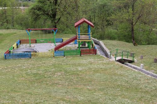 a playground with a slide in a field at BB Etno House in Kolašin