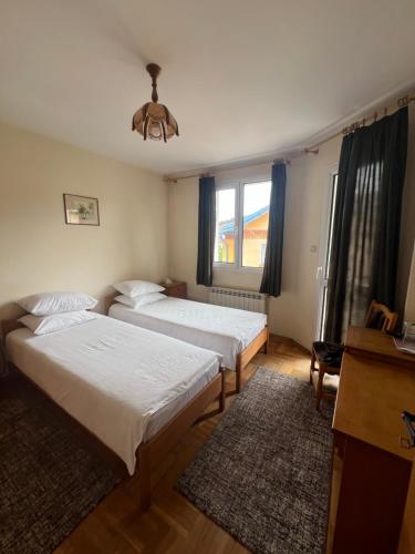 a bedroom with two beds and a window at Niko Hotel in Samokov