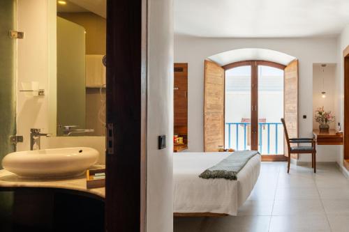 a bedroom with a bed and a sink and a bathroom at The Promenade in Pondicherry