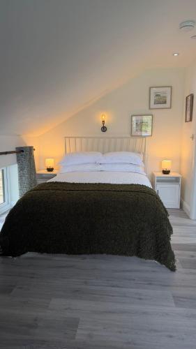 a bedroom with a large bed with a black blanket at The Loft in Gwys Station