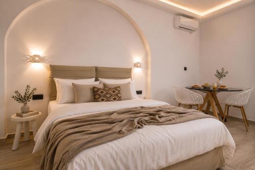 a bedroom with a large bed and a table at Aegeeis in Perissa