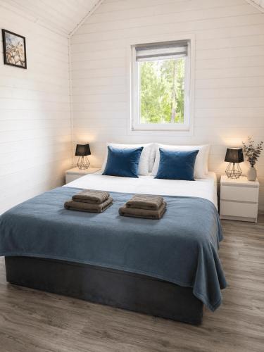 a bedroom with a large bed with two towels on it at Biały Koral in Rusinowo
