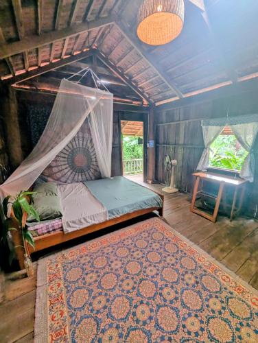 a bedroom with a bed with a canopy and a rug at Berry homestay 1 in Buon Ma Thuot