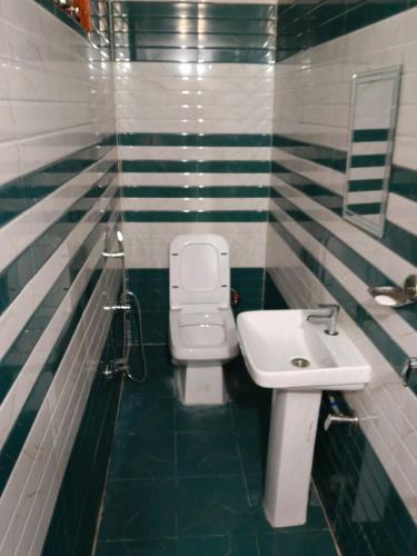 a bathroom with a toilet and a sink at Vinod Tourist Lodge in Gupta Kāshi