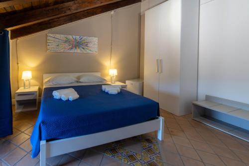 a bedroom with a blue bed with two towels on it at Hotel Sant'Antonio in Torraca
