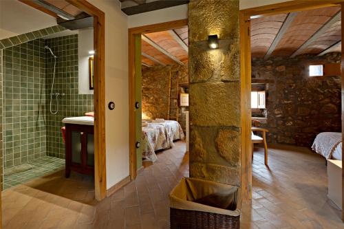 a bathroom with a shower and a room with two beds at L'Antic ajuntament de la Torra in La Baronia de Rialb