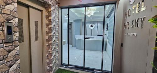 a glass door of a building with a sign on it at Hotel HR Sky in Ahmedabad