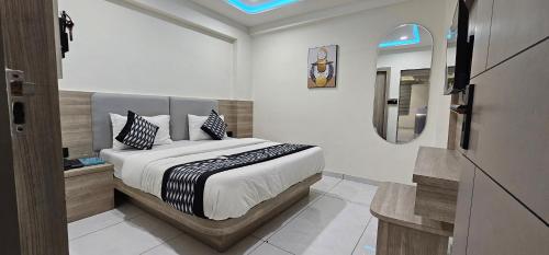 a bedroom with a bed and a mirror in it at Hotel HR Sky in Ahmedabad